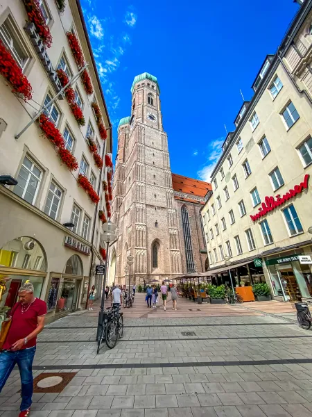 Our Lady's Cathedral in Munich, Germany, dominates a charming street scene.