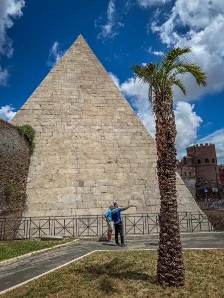 Tourists exploring the Pyramid of Cestius in Rome.