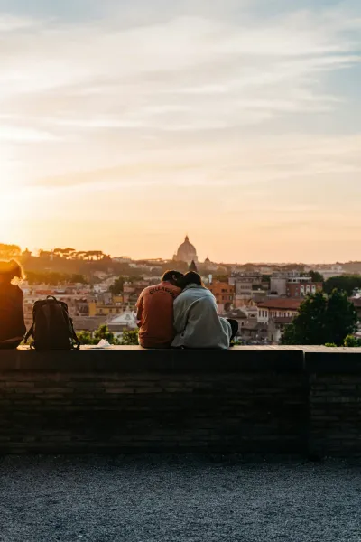 Couples enjoying sunset view of Rome with St. Peter's Basilica in the background.