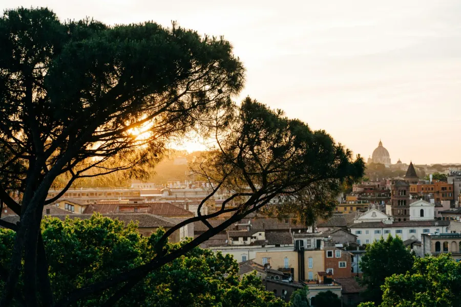 Sunset view of Rome, Italy, with St. Peter's Basilica in the distance.