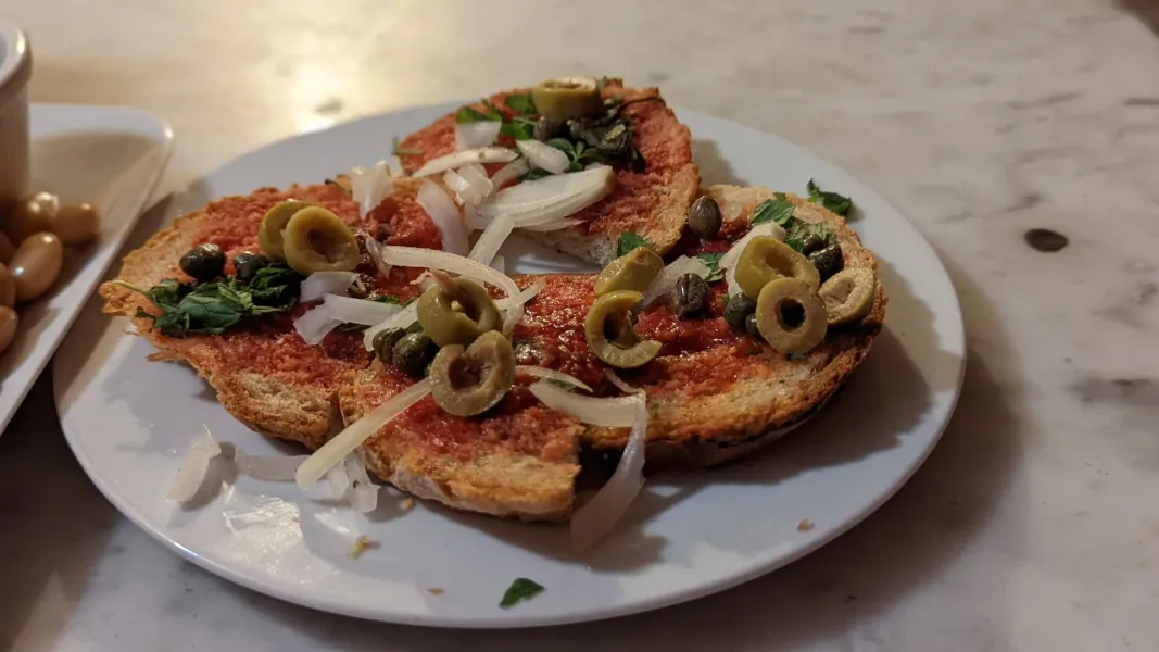 Delicious tapas with olives and capers on toasted bread in Rome.