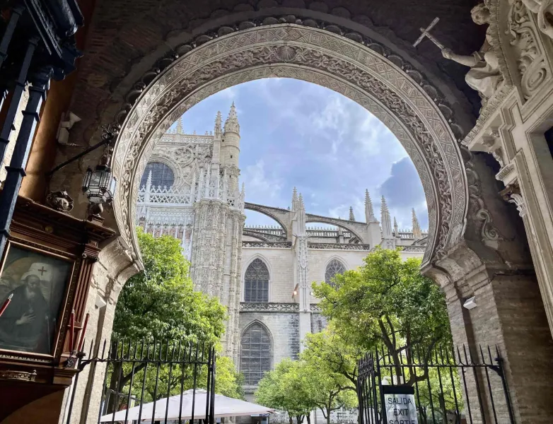 Stunning view of Seville Cathedral through an ornate archway.