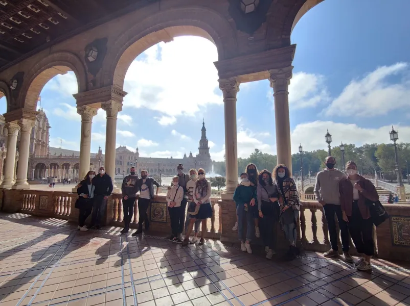 A tour group smiles in Seville's Plaza de España.