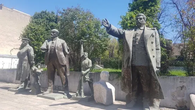 Weathered statues of communist leaders in a Tirana park.