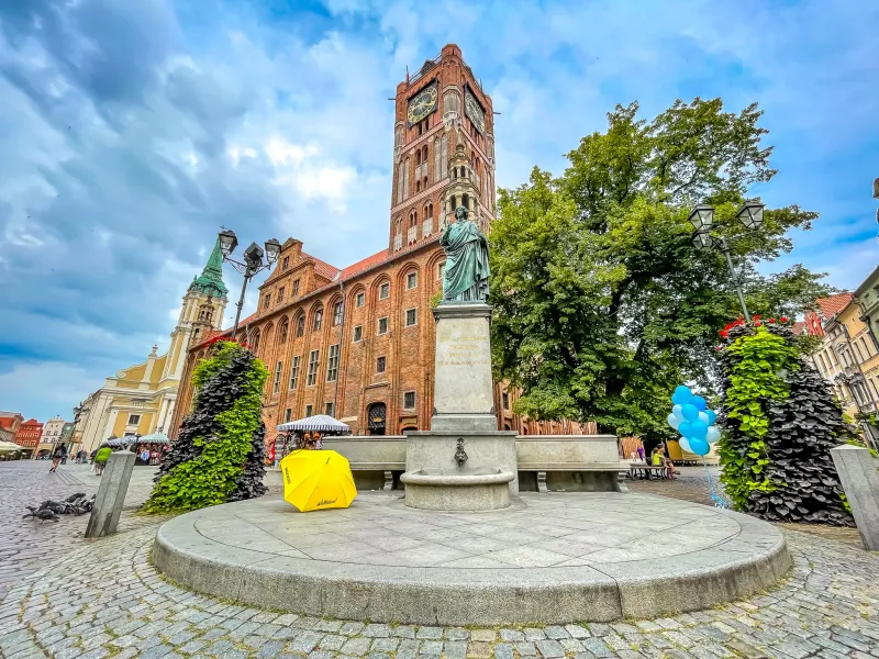 Explore the charming Old Town Hall and Nicolaus Copernicus statue in Toruń, Poland.
