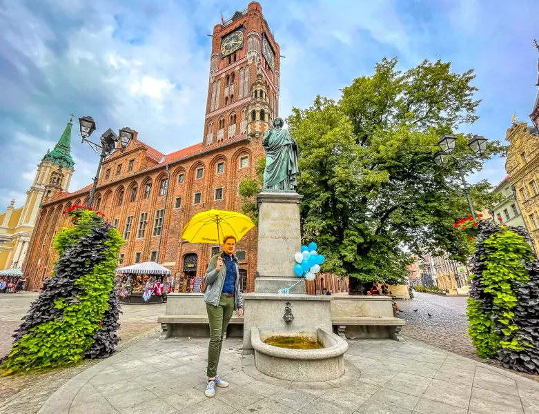 Explore Toruń's Old Town: The majestic Town Hall and Nicolaus Copernicus statue.