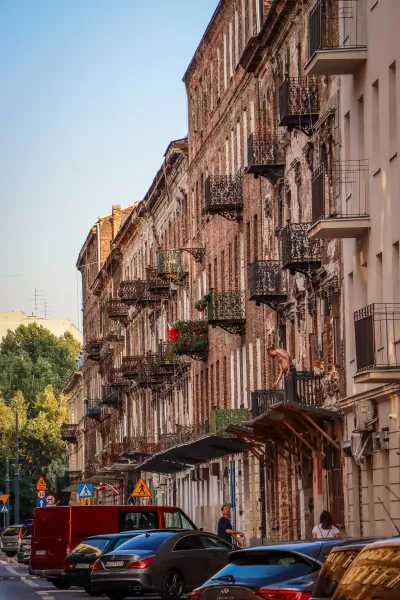 Historic buildings with ornate balconies line a Warsaw street.