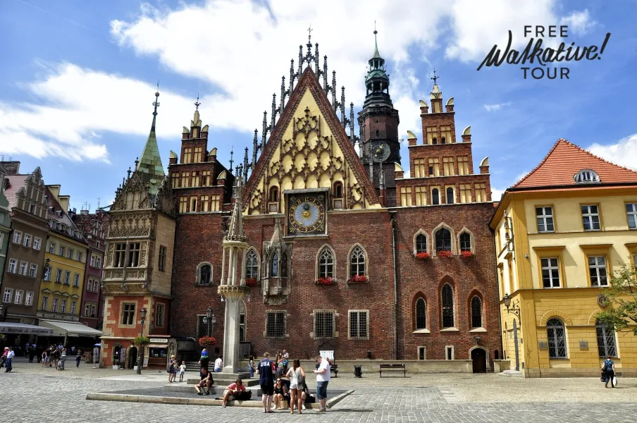 Tourists enjoying a free Walkative! tour in Wrocław's Old Town Square, admiring the stunning Old Town Hall.