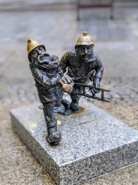 Two bronze firefighter dwarves in Wrocław, Poland.
