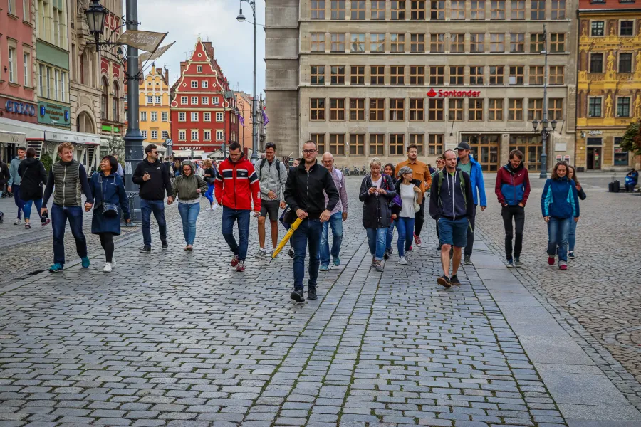 A guided walking tour group explores the historic streets of Wrocław, Poland.