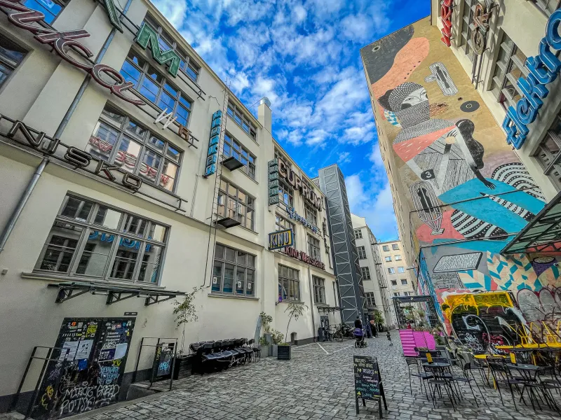 Colorful alleyway in Wrocław, Poland, with street art and a cinema.