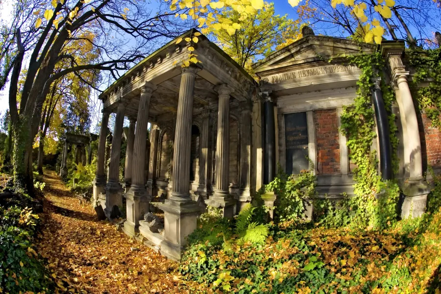 Autumnal scene in Wroclaw's historic cemetery, featuring a grand mausoleum.