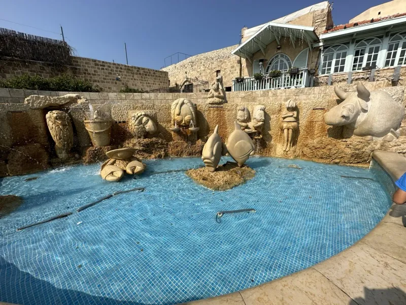 Whimsical fountain with sculpted figures, a charming travel destination.