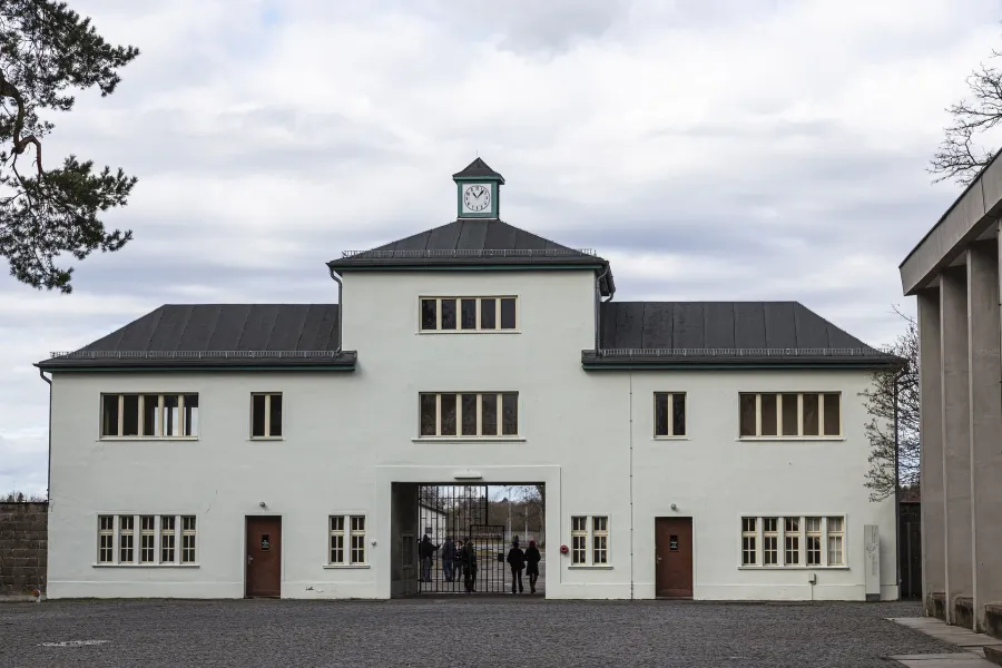 Entrance gate to a historical site, with visitors walking through.
