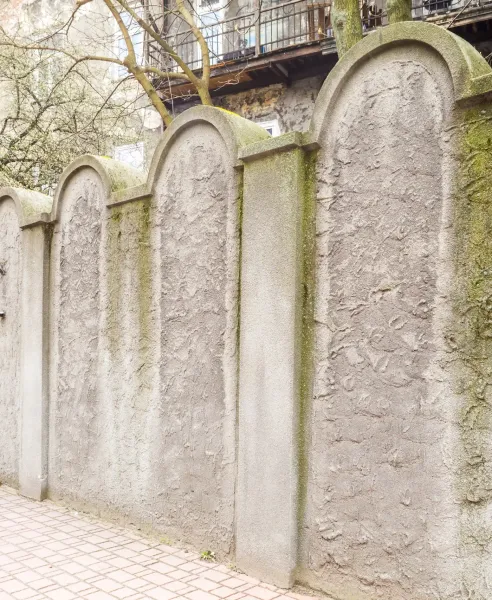 A section of the Krakow Ghetto wall memorial, whose arched top resembles a Jewish tombstone (matzevah).
