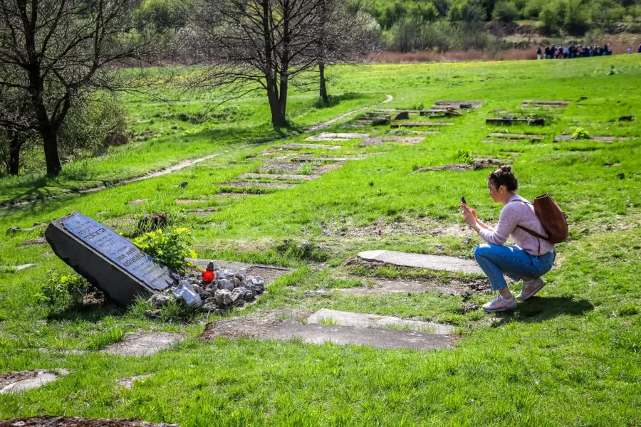 Tourist taking a photo at the Płaszów memorial in Krakow, Poland.