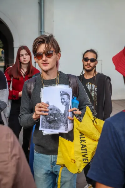 A tour guide shows a group a historical photo of a Polish soldier with Wojtek the Bear during a walking tour in Krakow.