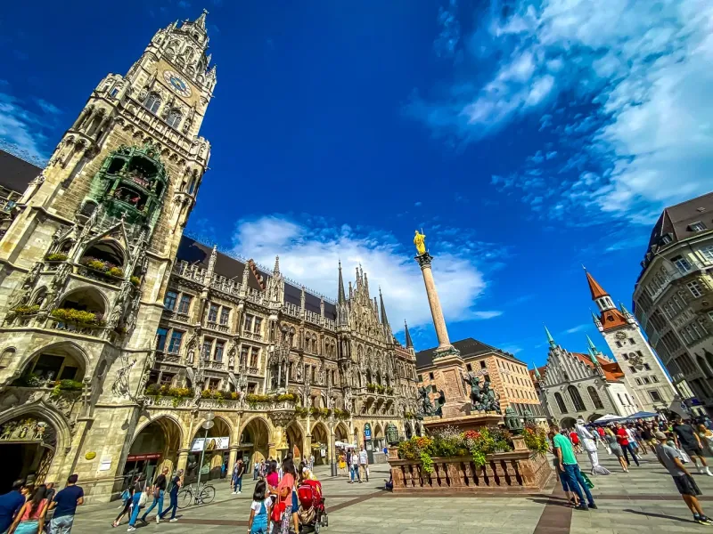 Tourists exploring Marienplatz in Munich, Germany, with the iconic New Town Hall in the background.