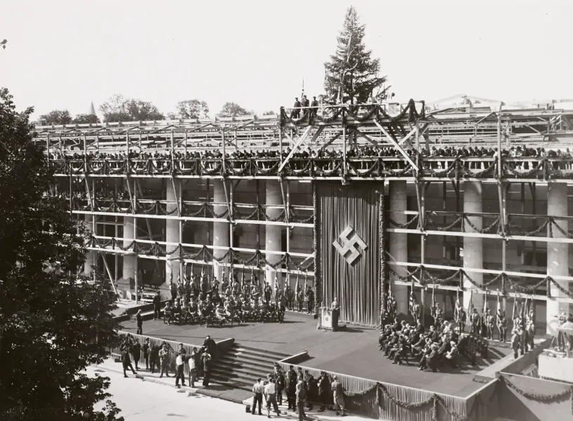 Historical photo of the Haus der Kunst topping-out ceremony in Munich, featuring scaffolding and Nazi banners.