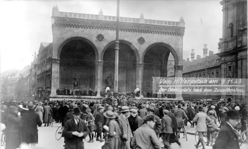 Black and white historical photo of a large crowd gathered in front of the Feldherrnhalle at Odeonsplatz in Munich.