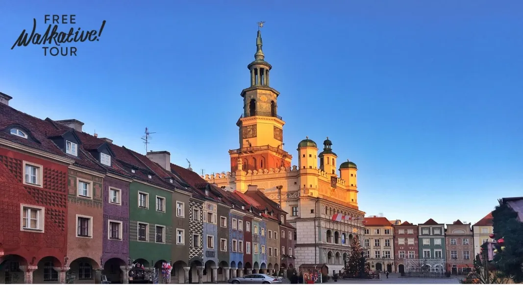 Poznań Old Town Hall with a tall clock tower, surrounded by colorful historic merchant houses under a clear blue sky.