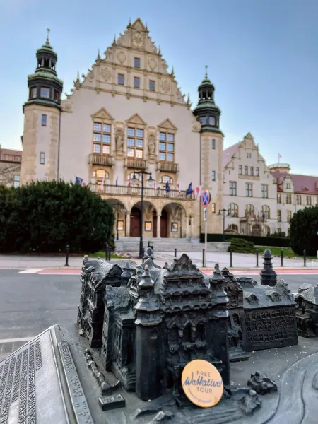 Bronze architectural model of old town buildings in the foreground, with the grand Collegium Minus of Adam Mickiewicz Univ...