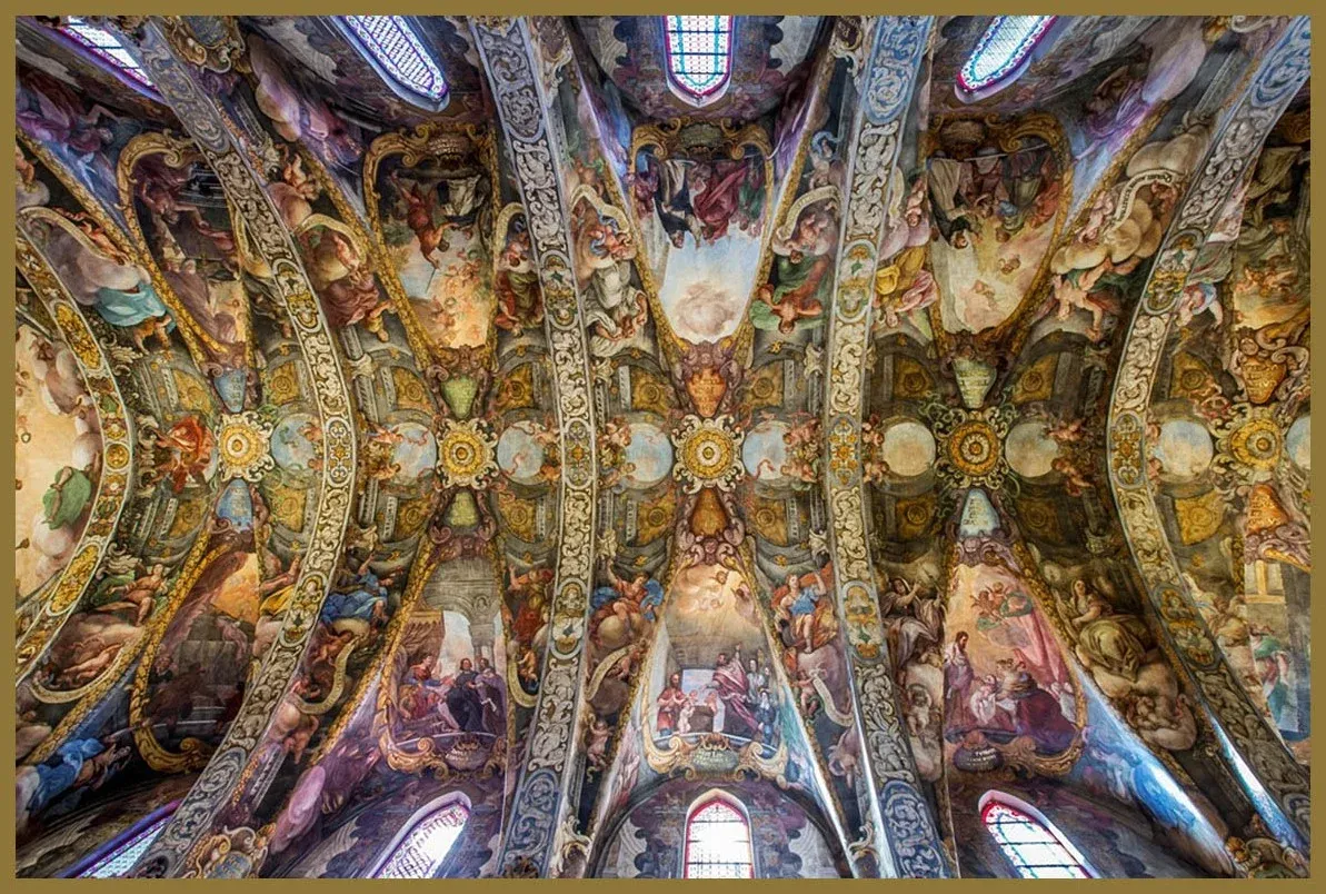 The ornate, frescoed vaulted ceilings of the Church of San Nicolás in Valencia, depicting religious scenes.
