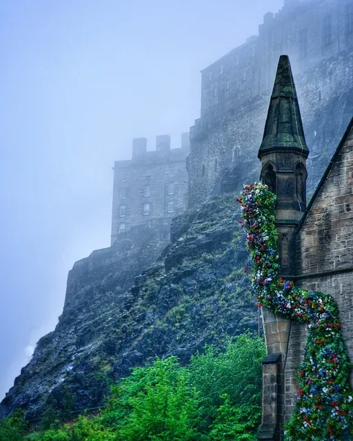 Edinburgh Castle shrouded in fog, with a flower-decorated building in the foreground.