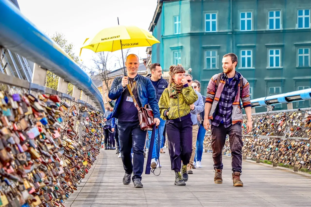 A Walkative tour group explores Krakow, Poland, walking across a bridge covered in love locks.