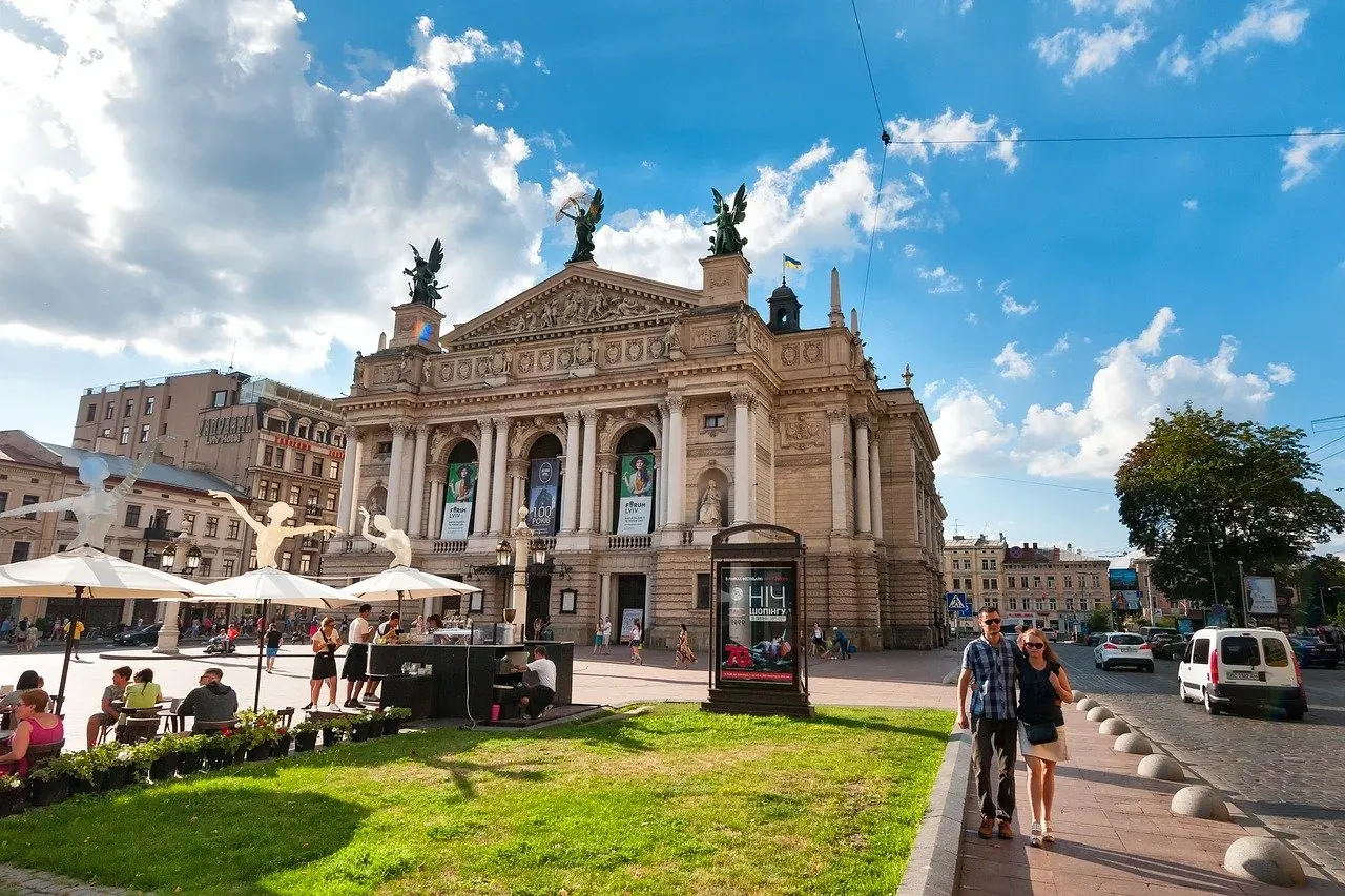 Tourists enjoying the sunny square in front of the magnificent Lviv Opera House in Ukraine.