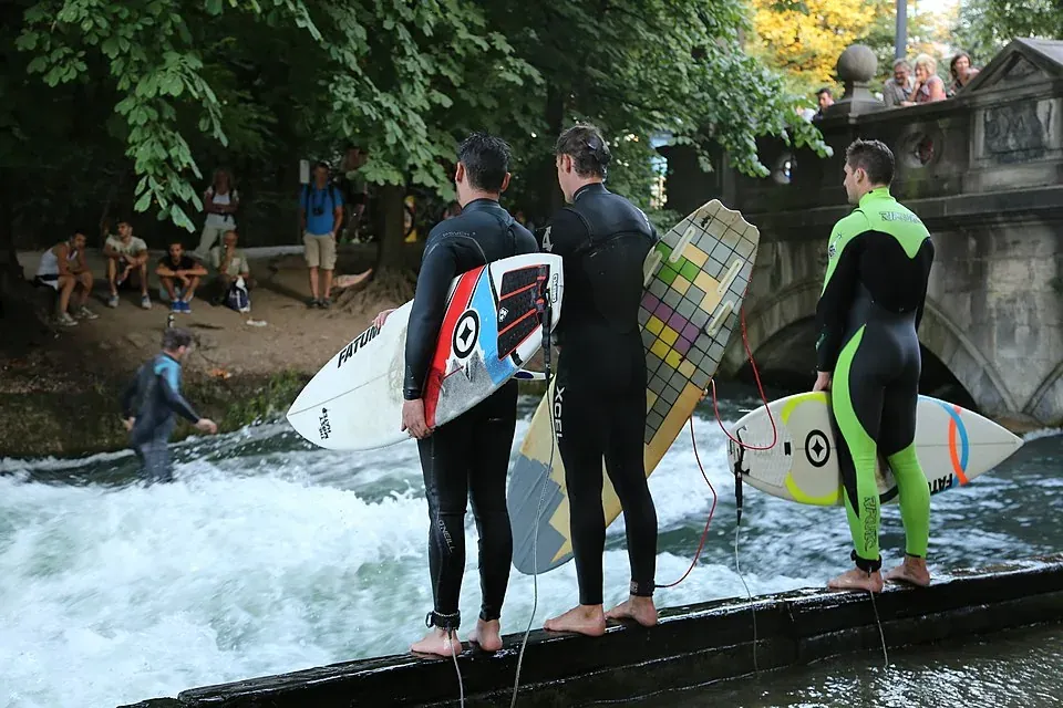 Surfers prepare to ride the Eisbach wave in Munich's Englischer Garten.