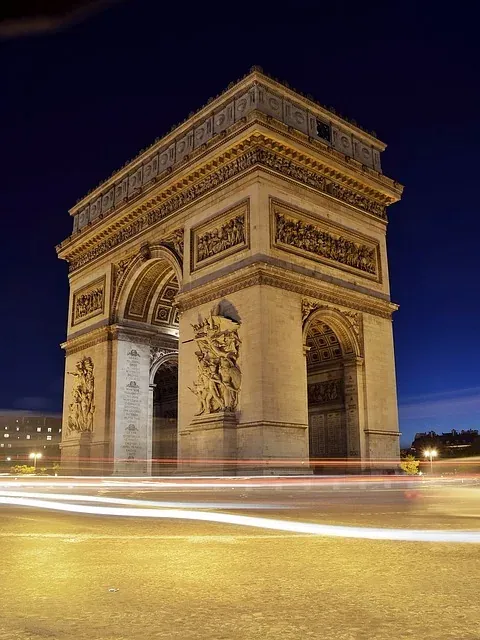 The Arc de Triomphe in Paris at night, illuminated beautifully.