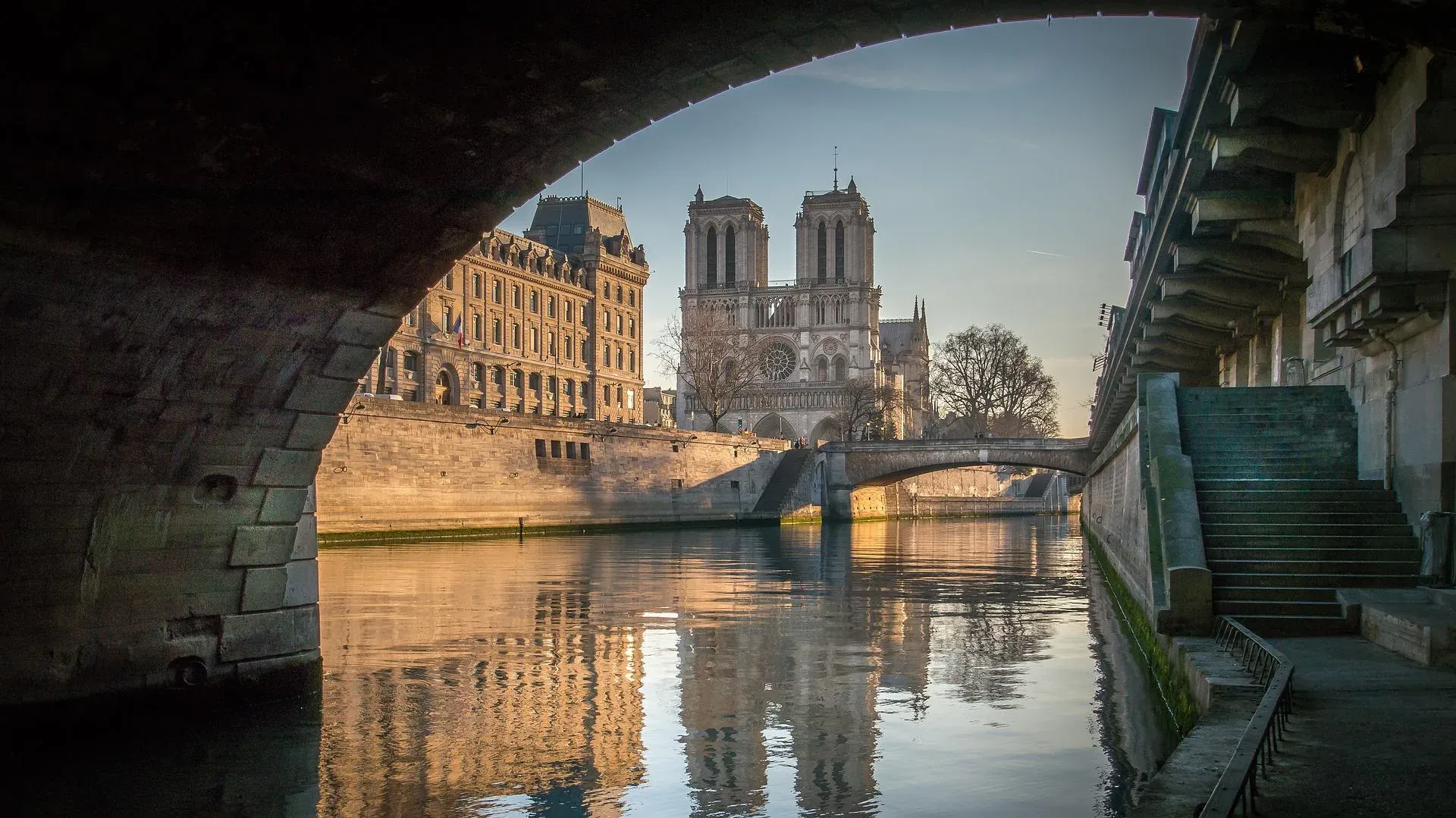 Stunning view of Notre Dame Cathedral in Paris, reflected in the Seine River.