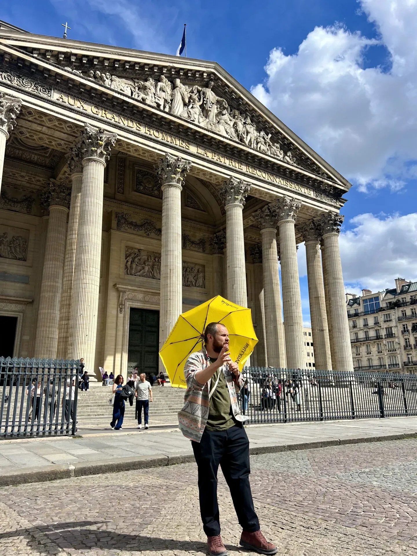A tour guide leads a group through the Latin Quarter in Paris, showcasing the Panthéon.