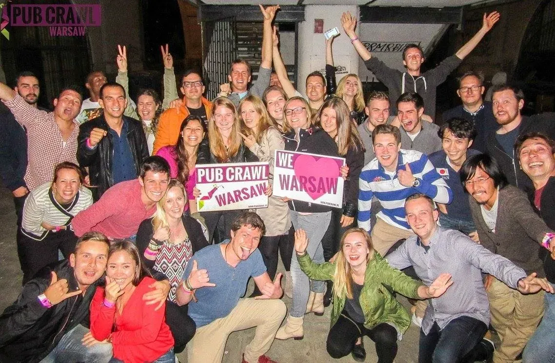 A large group of happy tourists on a pub crawl in Warsaw, Poland.