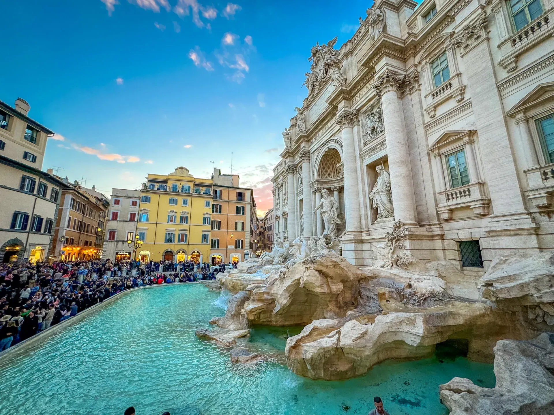 Tourists admiring the Trevi Fountain in Rome during a guided walking tour.