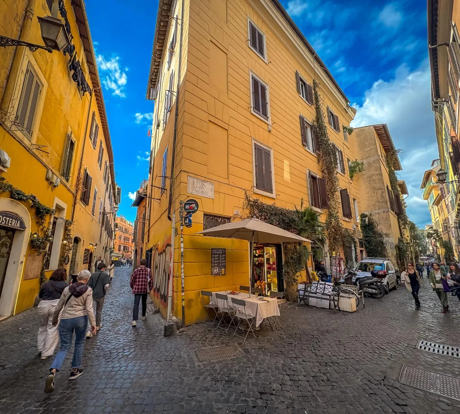 Tourists exploring the charming cobblestone streets of Trastevere, Rome.
